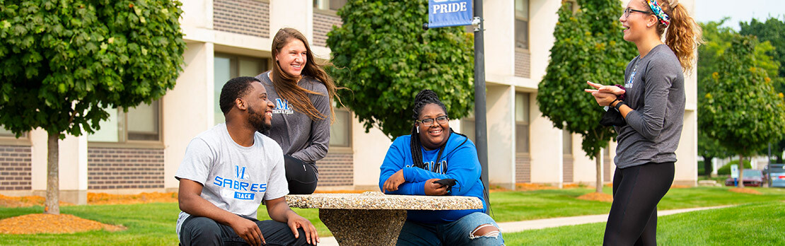 Group of Marian University student sitting outside on campus. Learn about Marian's undeclared major.