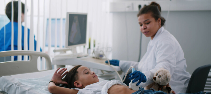A pediatric sonographer takes an ultrasound image of a young patient’s abdominal cavity.