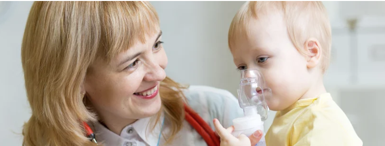Nurse helping toddler use a breathing mask.